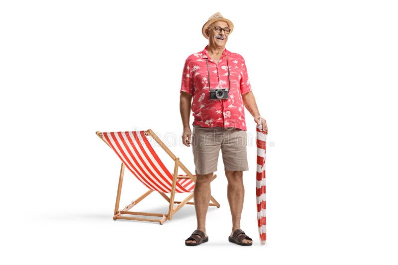 Uomo che tiene un ombrello sulla spiaggia e sta in piedi accanto a una sedia sulla spiaggia immagini stock libere da diritti