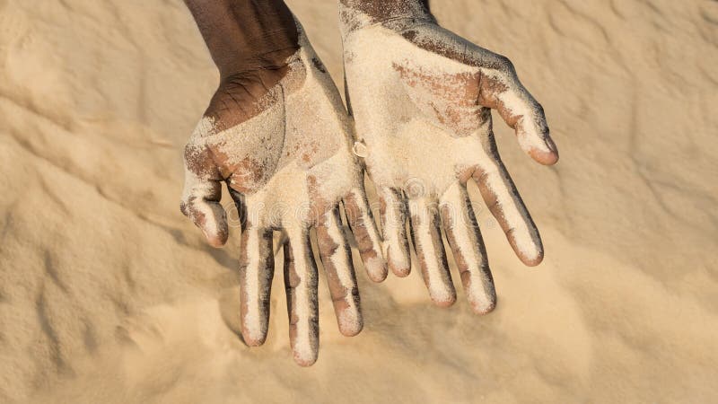 Uomo che tiene una certa sabbia nella mano fotografia stock Uomo che tiene una certa sabbia nella mano fotografia stock