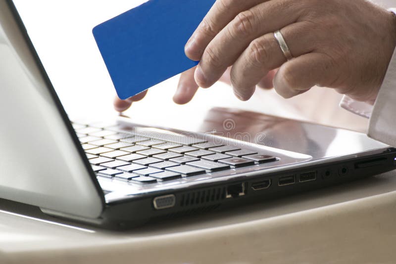 Uomo che usando un web di attività bancarie online che tiene una carta di credito e un computer portatile spazio vuoto della copi immagine stock libera da diritti Uomo che usando un web di attività bancarie online che tiene una carta di credito e un computer portatile spazio vuoto della copi immagine stock libera da diritti