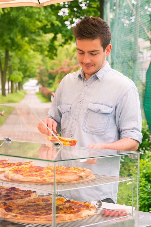 Uomo che vende pizza dalla fetta fotografia stock libera da diritti Uomo che vende pizza dalla fetta fotografia stock libera da diritti