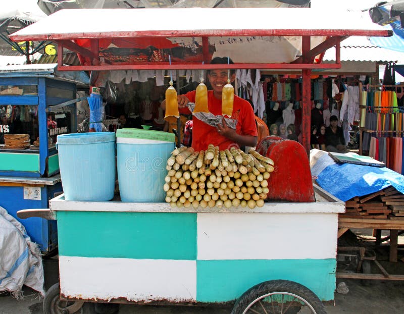 UOMO CHE VENDE SUGAR CANE JUICE FRESCO IN INDONESIA fotografia stock UOMO CHE VENDE SUGAR CANE JUICE FRESCO IN INDONESIA fotografia stock