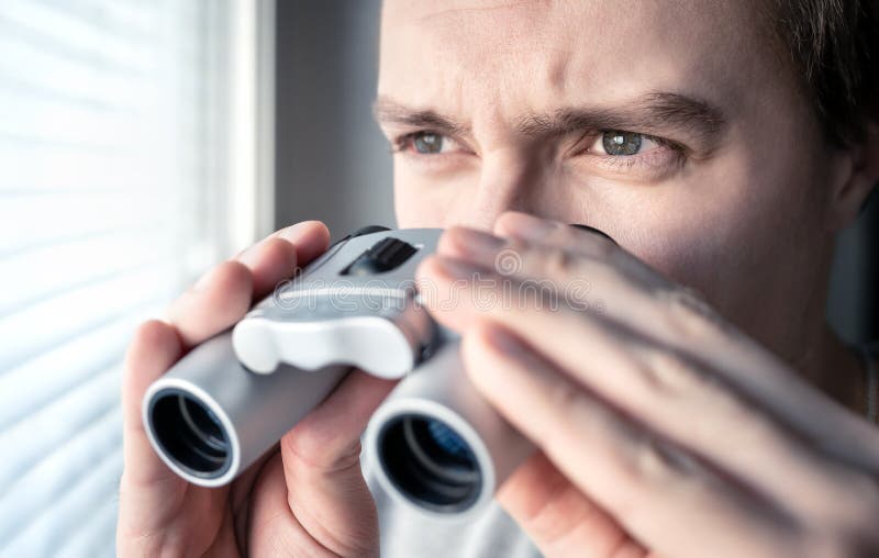 Uomo con il binocolo Agente investigativo privato, agente o ricercatore guardanti fuori la finestra Uomo che spia o che studia fotografie stock Uomo con il binocolo Agente investigativo privato, agente o ricercatore guardanti fuori la finestra Uomo che spia o che studia fotografie stock