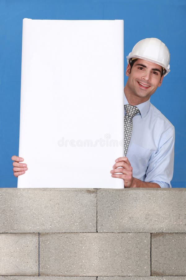 Uomo con il comitato bianco sulla parete fotografia stock