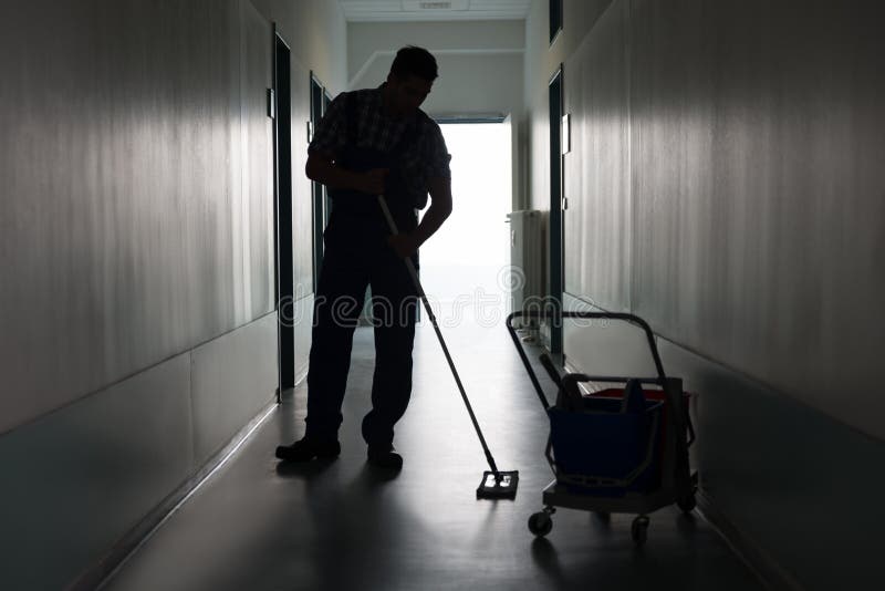 Full length of silhouette man with broom cleaning office corridor. Full length of silhouette man with broom cleaning office corridor