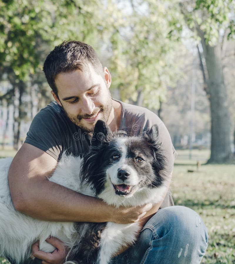 Uomo con il suo cane che gioca nel parco immagine stock libera da diritti Uomo con il suo cane che gioca nel parco immagine stock libera da diritti