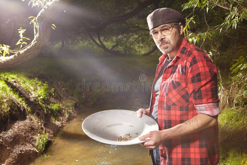 Uomo con l'insenatura di alluminio di cottura della pentola per oro immagini stock Uomo con l'insenatura di alluminio di cottura della pentola per oro immagini stock