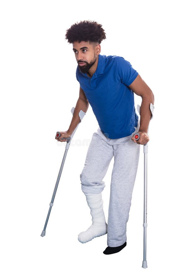 Uomo con la gamba rotta facendo uso delle grucce fotografia stock Uomo con la gamba rotta facendo uso delle grucce fotografia stock