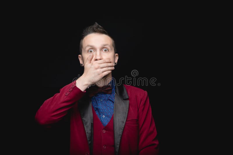Uomo con la giacca rossa e la bocca chiusa Sfondo isolato nero concetto di libertà di parola fotografia stock libera da diritti