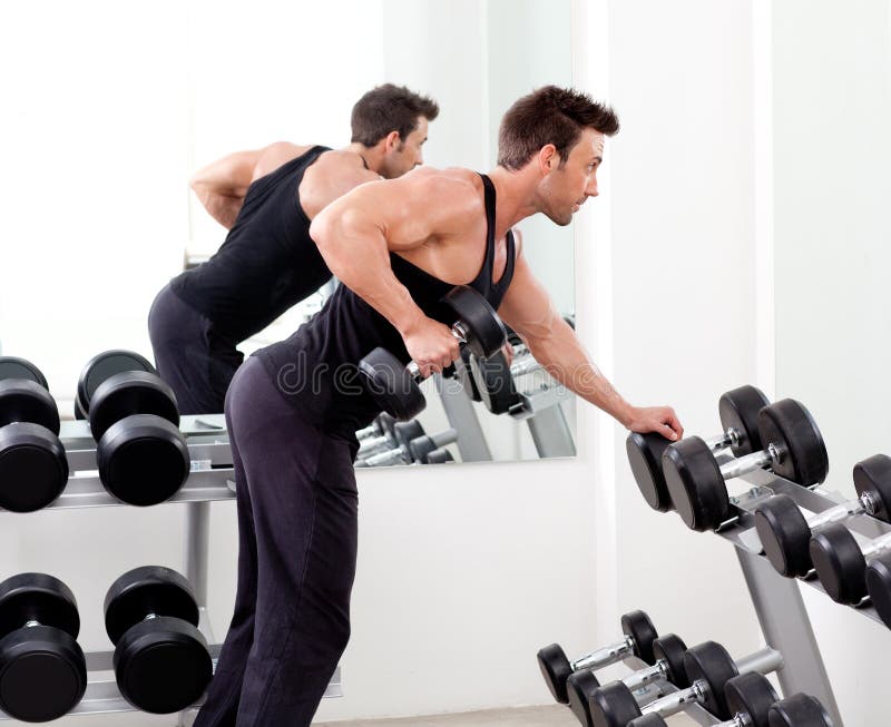 Uomo con la strumentazione di addestramento del peso su ginnastica di sport immagini stock Uomo con la strumentazione di addestramento del peso su ginnastica di sport immagini stock