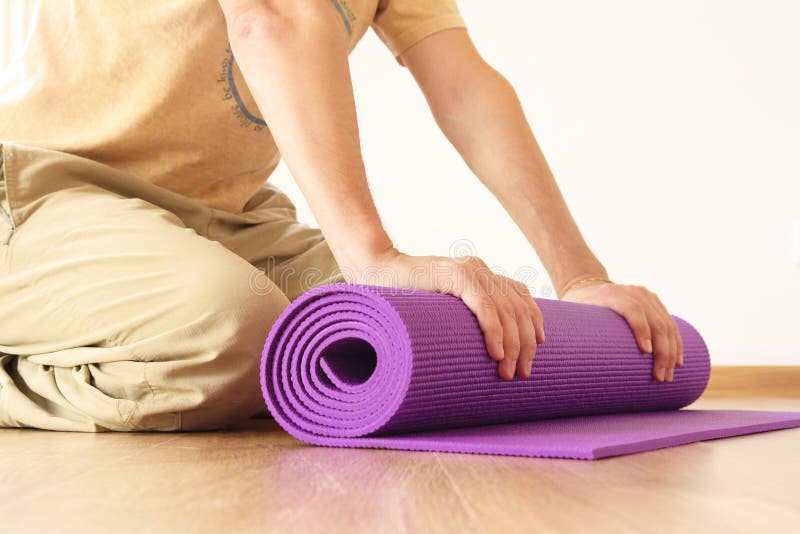 Uomo con la stuoia di yoga fotografia stock libera da diritti Uomo con la stuoia di yoga fotografia stock libera da diritti