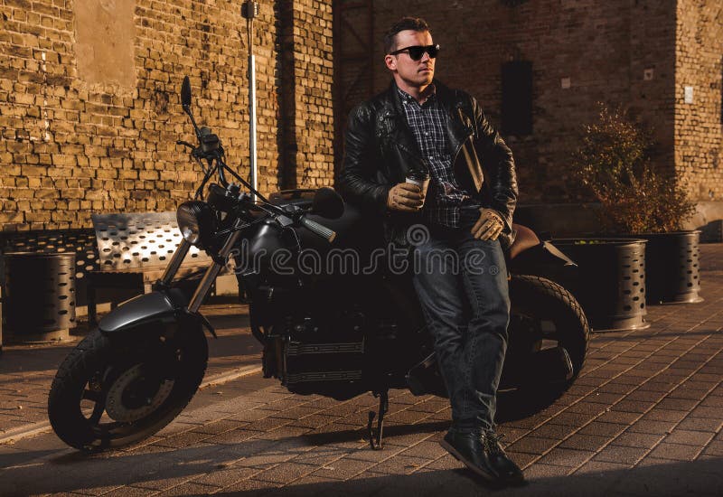 Uomo con un motociclo del caffè-corridore immagine stock libera da diritti Uomo con un motociclo del caffè-corridore immagine stock libera da diritti