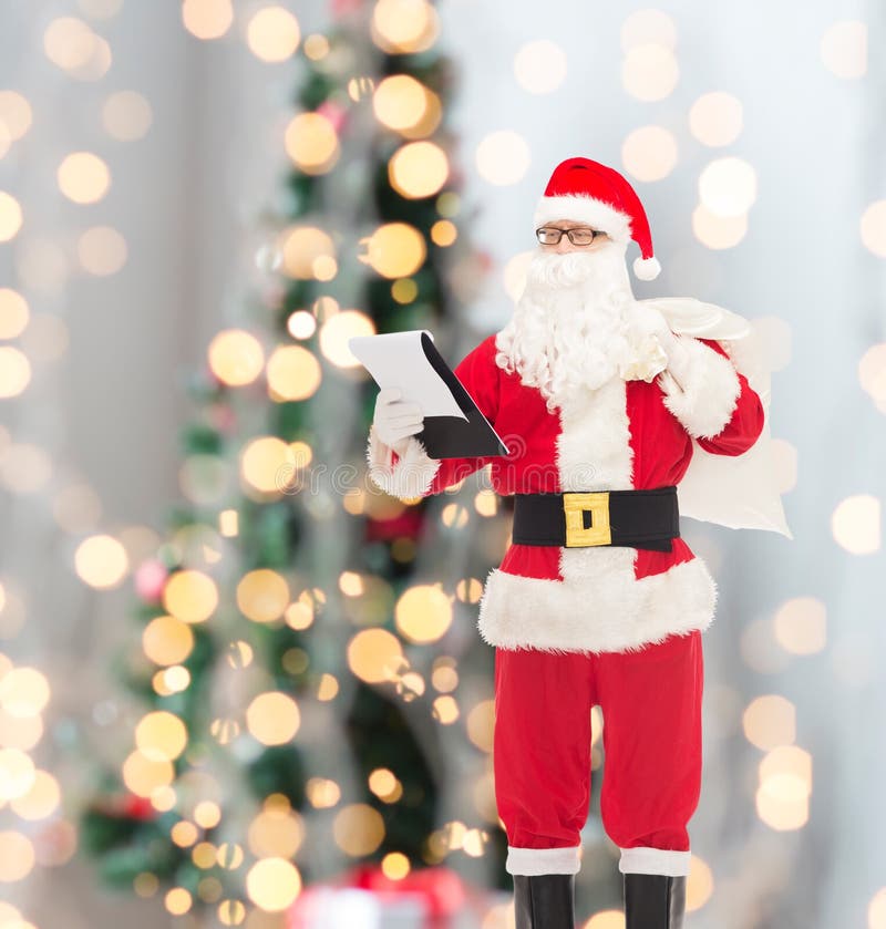 Uomo in costume del Babbo Natale con il blocco note e la borsa immagine stock libera da diritti Uomo in costume del Babbo Natale con il blocco note e la borsa immagine stock libera da diritti