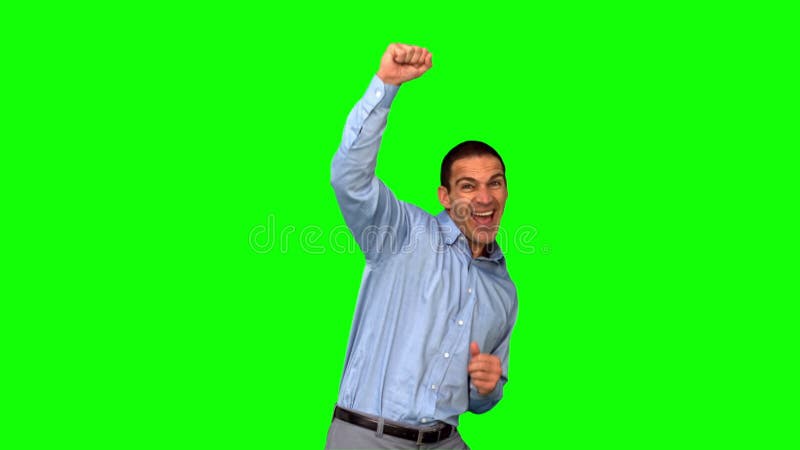 Uomo d'affari allegro che alza il suo pugno sullo schermo verde
