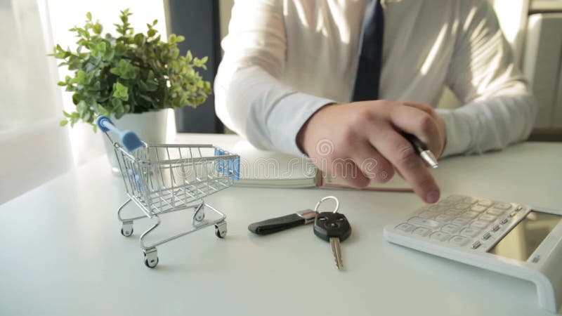 Uomo d'affari che calcola le spese di acquisto, detenendo le entrate a disposizione Carrello vuoto davanti Finanze interne, inves