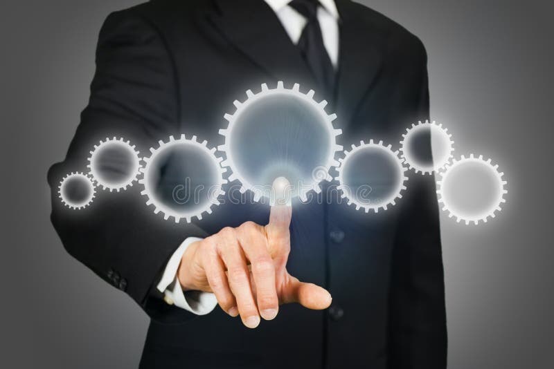 Uomo d'affari che clicca sugli ingranaggi fotografia stock libera da diritti
