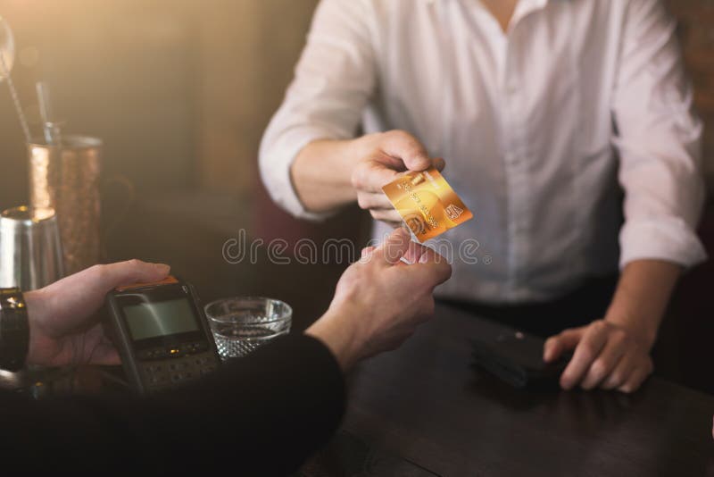 Uomo d'affari che dà credito carta al barista fotografia stock libera da diritti Uomo d'affari che dà credito carta al barista fotografia stock libera da diritti