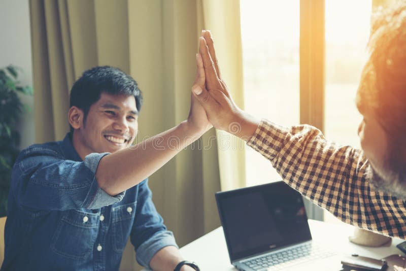 Uomo d'affari che dà su cinque al suo partner sulla riunione fotografie stock Uomo d'affari che dà su cinque al suo partner sulla riunione fotografie stock