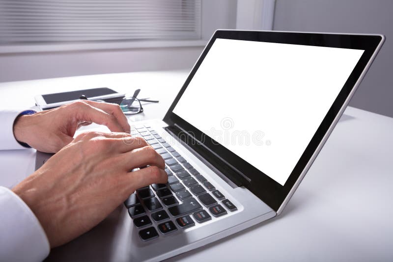 Uomo d'affari che per mezzo del computer portatile fotografia stock