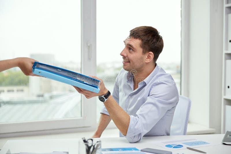 Uomo d'affari che prende le carte da segretario in ufficio fotografia stock Uomo d'affari che prende le carte da segretario in ufficio fotografia stock