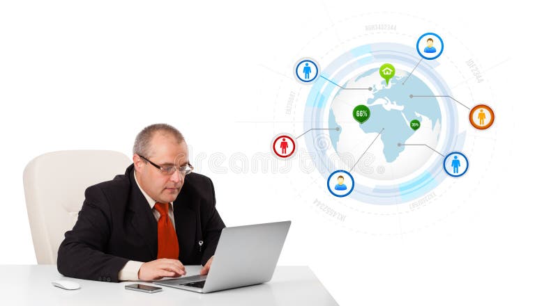 Uomo d'affari che si siede allo scrittorio e che guarda computer portatile con il globo e così immagine stock libera da diritti Uomo d'affari che si siede allo scrittorio e che guarda computer portatile con il globo e così immagine stock libera da diritti