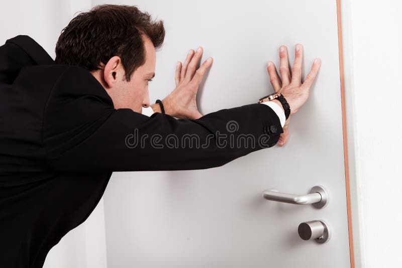 Uomo d'affari che spinge il portello immagine stock Uomo d'affari che spinge il portello immagine stock