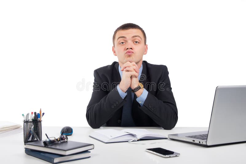 Uomo d'affari che vi esamina scettico che vi sedete al suo scrittorio immagine stock libera da diritti Uomo d'affari che vi esamina scettico che vi sedete al suo scrittorio immagine stock libera da diritti