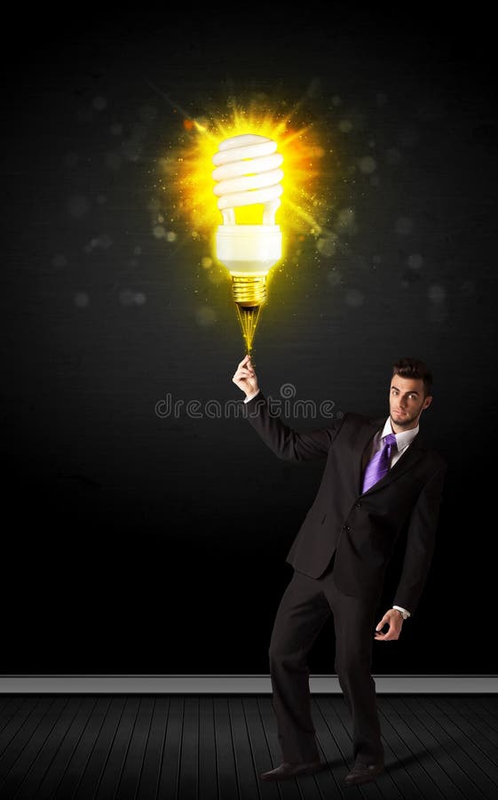 Uomo d'affari con una lampadina ecologica fotografie stock Uomo d'affari con una lampadina ecologica fotografie stock