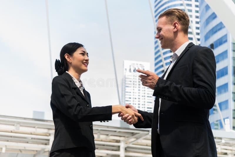 Uomo d'affari e donna di affari che stringono le mani per la dimostrazione del loro accordo firmare accordo o contratto fra le lo immagini stock libere da diritti Uomo d'affari e donna di affari che stringono le mani per la dimostrazione del loro accordo firmare accordo o contratto fra le lo immagini stock libere da diritti