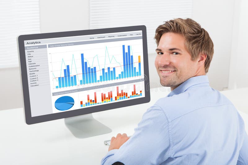 Uomo d'affari felice che analizza i grafici finanziari sul computer fotografie stock Uomo d'affari felice che analizza i grafici finanziari sul computer fotografie stock