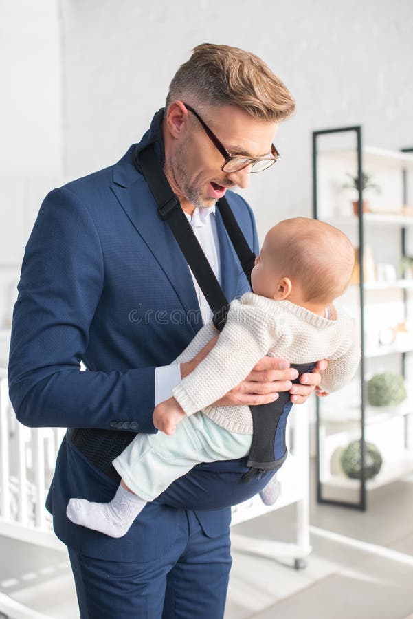 uomo d'affari felice che esamina figlia infantile fotografia stock uomo d'affari felice che esamina figlia infantile fotografia stock