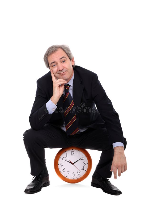 Uomo d'affari felice che si siede su un orologio