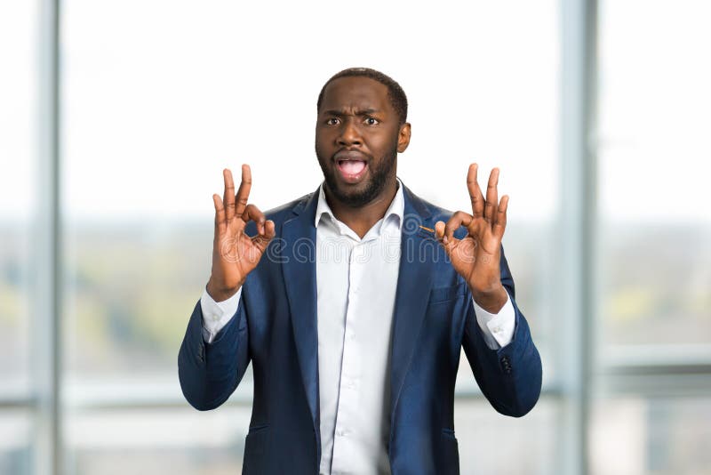 Uomo d'affari nero che gesturing OKAY fotografie stock libere da diritti Uomo d'affari nero che gesturing OKAY fotografie stock libere da diritti