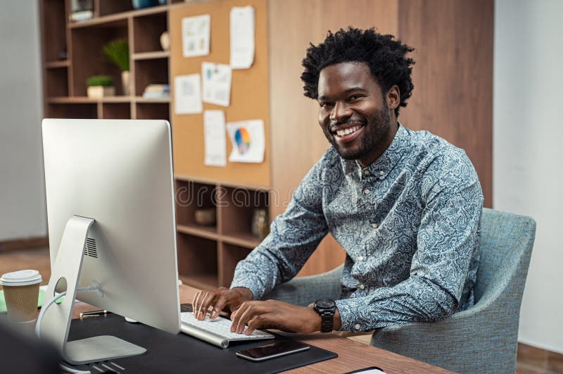Uomo d'affari nero creativo che lavora al computer fotografia stock Uomo d'affari nero creativo che lavora al computer fotografia stock