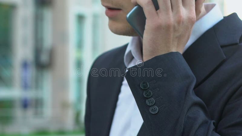 Uomo d'affari occupato che risponde sulla telefonata all'aperto, comunicazione, tecnologie