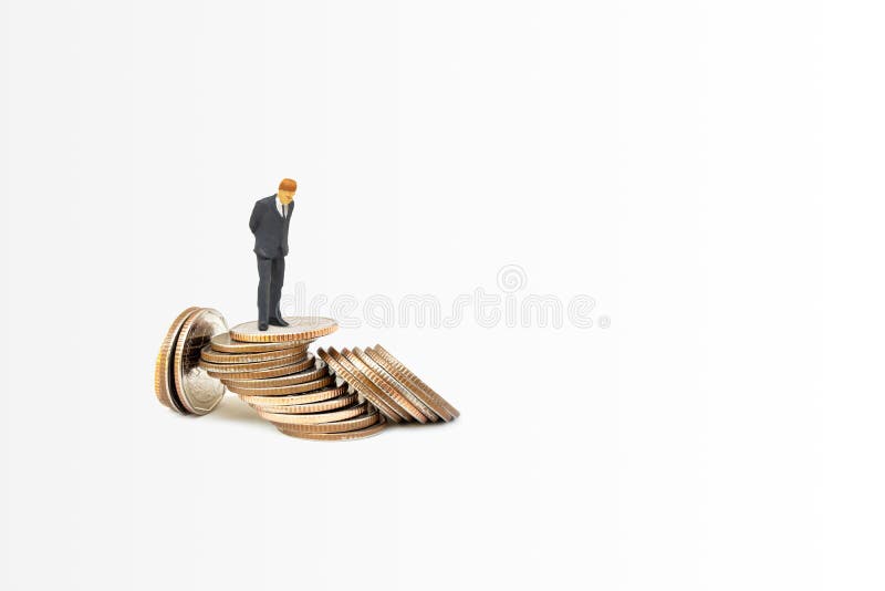 Uomo d'affari in piedi su monete d'argento in pila che cadono a terra fotografia stock libera da diritti Uomo d'affari in piedi su monete d'argento in pila che cadono a terra fotografia stock libera da diritti