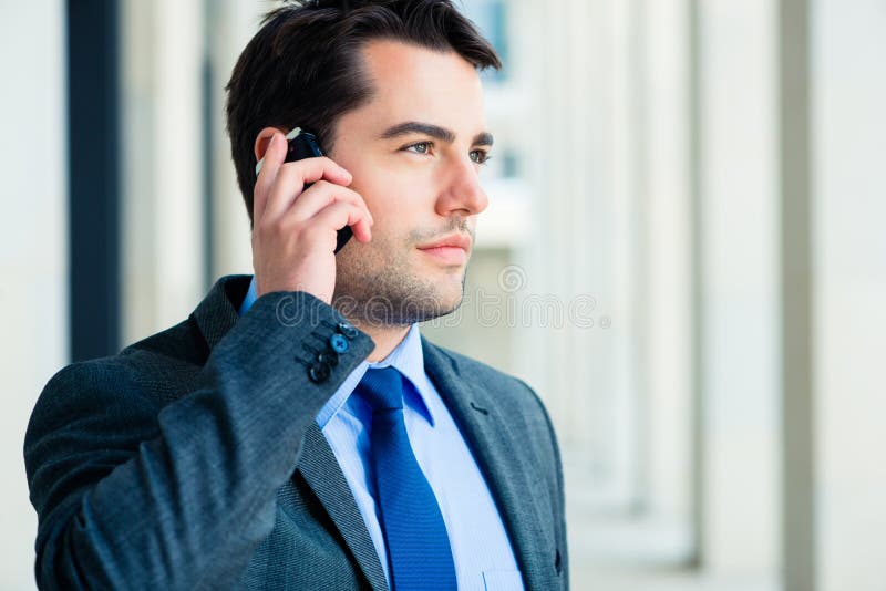 Uomo d'affari sicuro all'aperto facendo uso del telefono immagini stock libere da diritti Uomo d'affari sicuro all'aperto facendo uso del telefono immagini stock libere da diritti