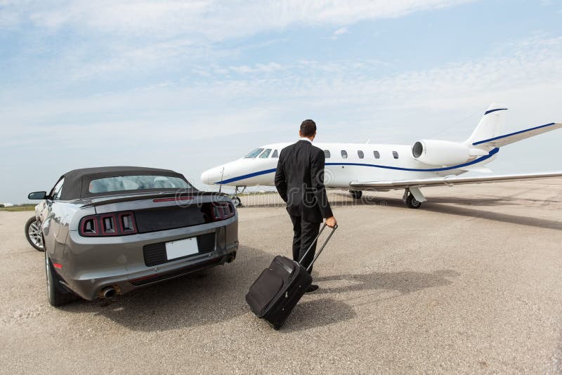 Uomo d'affari Standing By Car e Jet At privata