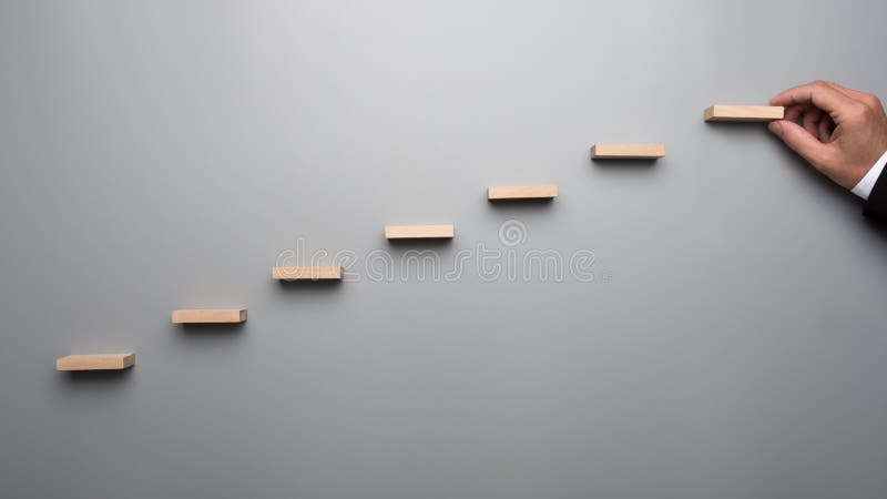 Uomo d'affari in vestito che costruisce un grafico o una scala di succe fotografia stock Uomo d'affari in vestito che costruisce un grafico o una scala di succe fotografia stock