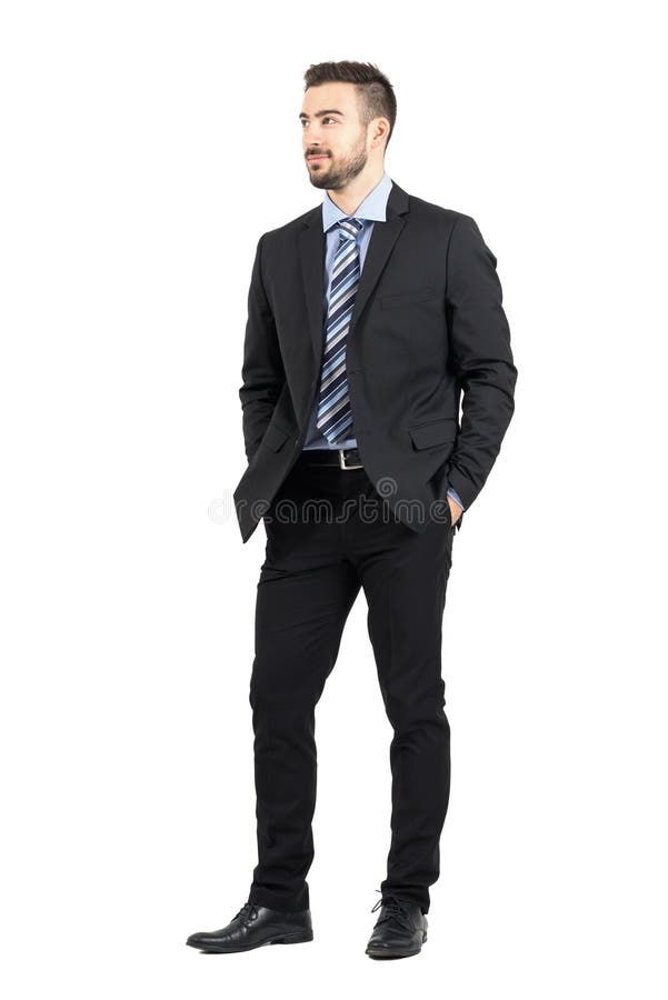 Uomo d'affari in vestito con le mani in tasche che sorride e che distoglie lo sguardo immagine stock libera da diritti Uomo d'affari in vestito con le mani in tasche che sorride e che distoglie lo sguardo immagine stock libera da diritti
