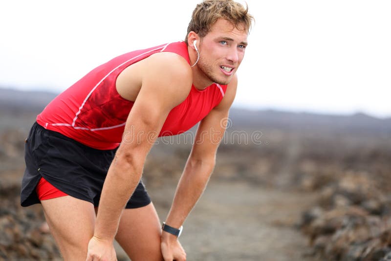 Uomo del corridore che riposa con la musica dopo avere corso immagine stock Uomo del corridore che riposa con la musica dopo avere corso immagine stock
