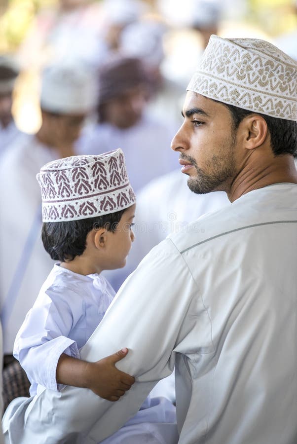 Uomo dell'Oman con suo figlio ad un mercato immagine stock Uomo dell'Oman con suo figlio ad un mercato immagine stock