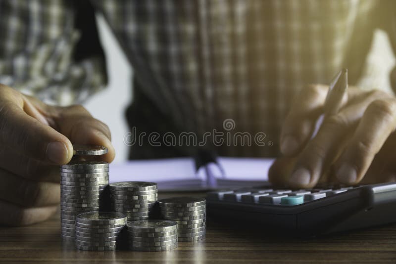 Uomo di affari che mette una moneta sulla cassa di risparmio della pila delle monete e rappresentare i suoi soldi tutti nel conce fotografie stock Uomo di affari che mette una moneta sulla cassa di risparmio della pila delle monete e rappresentare i suoi soldi tutti nel conce fotografie stock