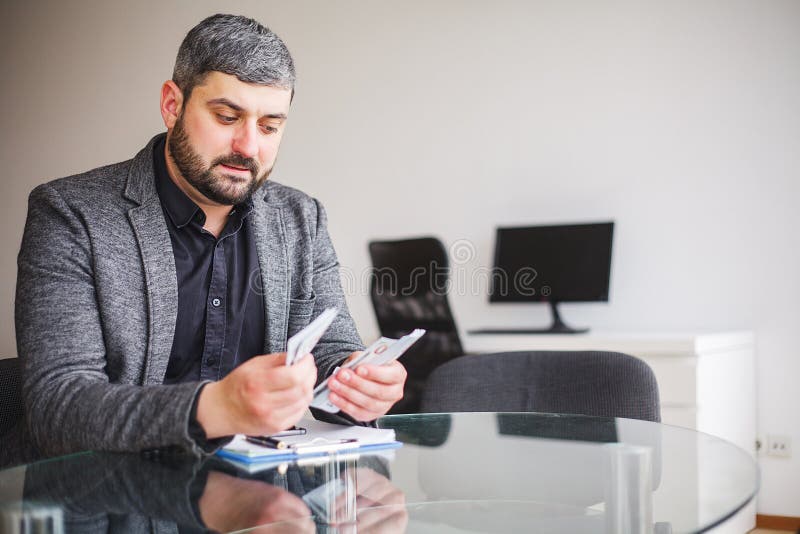 Uomo di affari che si siede allo scrittorio ed al contratto di firma L'uomo prende il dono per la firma del contratto Di alta ris fotografia stock libera da diritti Uomo di affari che si siede allo scrittorio ed al contratto di firma L'uomo prende il dono per la firma del contratto Di alta ris fotografia stock libera da diritti