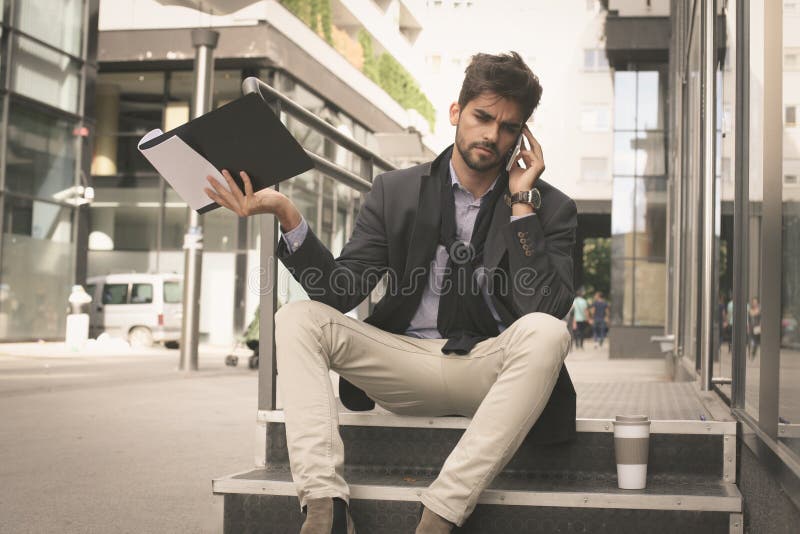 Uomo di affari sulla via che ha conversazione seria sul Mo immagini stock libere da diritti Uomo di affari sulla via che ha conversazione seria sul Mo immagini stock libere da diritti
