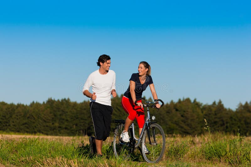 Uomo e donna che pareggiano e con la bicicletta