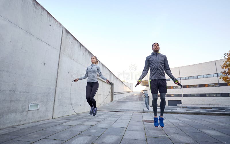 Uomo e donna che si esercitano con la salto-corda all'aperto fotografia stock