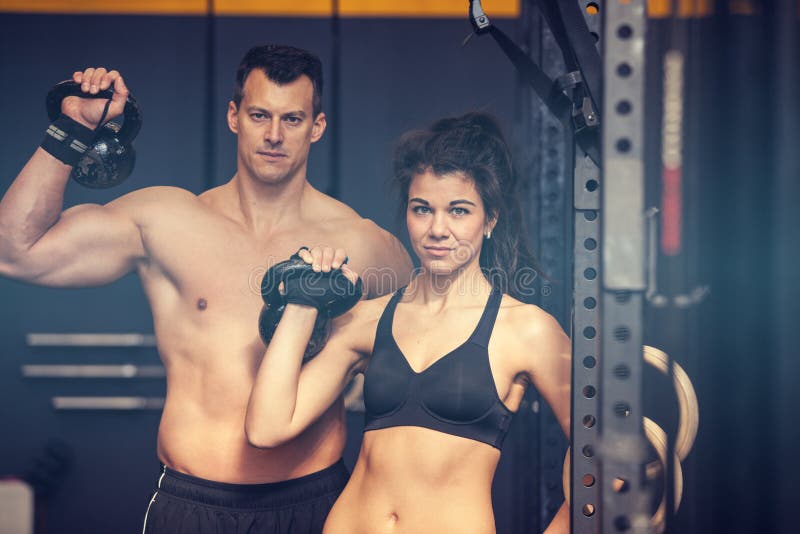 Uomo e donna di addestramento di Kettlebell in una palestra fotografie stock libere da diritti Uomo e donna di addestramento di Kettlebell in una palestra fotografie stock libere da diritti