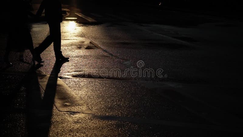 Uomo e giovane donna che camminano su una via Accoppi tenersi per mano alla loro data in una via al primo mattino, ombre della ci