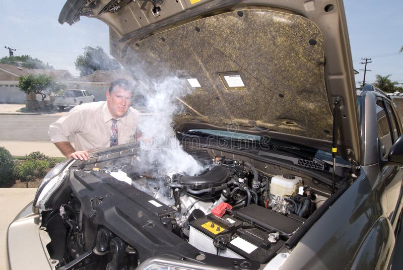A man is very frustrated and sweaty while trying to evaluate his smoking car engine. A man is very frustrated and sweaty while trying to evaluate his smoking car engine.