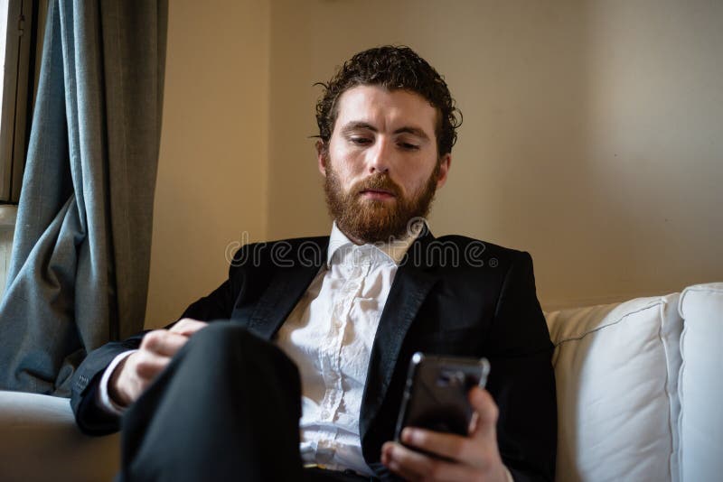 Uomo elegante dei pantaloni a vita bassa bei sul cellulare fotografia stock libera da diritti Uomo elegante dei pantaloni a vita bassa bei sul cellulare fotografia stock libera da diritti